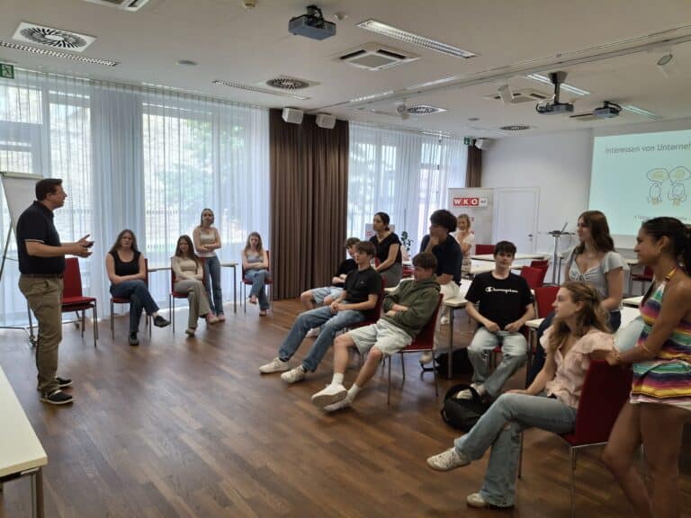 Vortragender mit Gruppe von Jugendlichen in einem Seminarraum in Wien